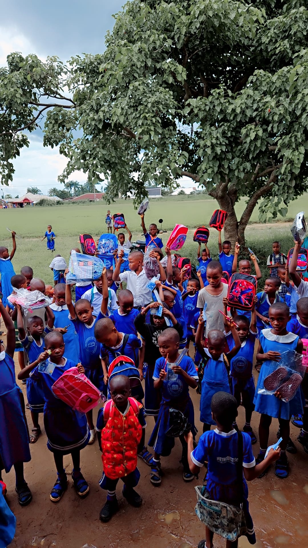 Children holding up their new backpacks and school supplies